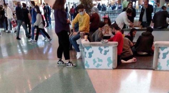 Masa ve sandalyelerin kaldırıldığı AVM'de, yerde yemek yediler