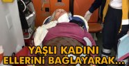 Yaşlı kadını ellerini bağlayarak..